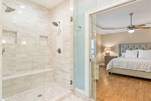 ensuite bathroom featuring wood finished floors, baseboards, ornamental molding, a shower stall, and connected bathroom