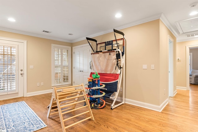 foyer entrance featuring visible vents, wood finished floors, baseboards, and ornamental molding