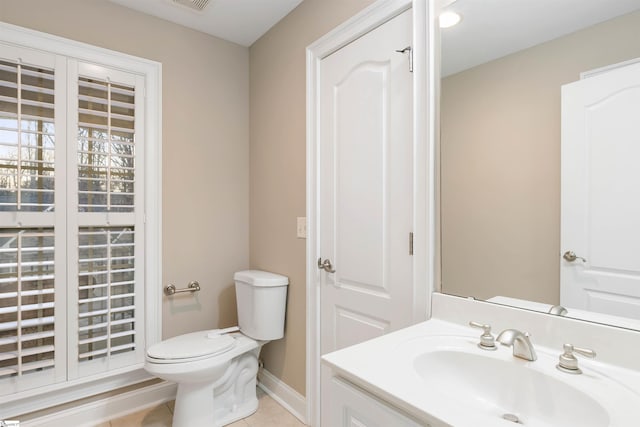 bathroom featuring vanity, visible vents, baseboards, tile patterned flooring, and toilet