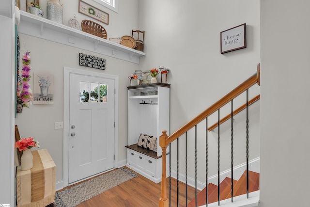 entrance foyer with stairway, wood finished floors, and baseboards