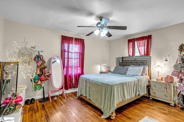 bedroom with baseboards, ceiling fan, and hardwood / wood-style flooring