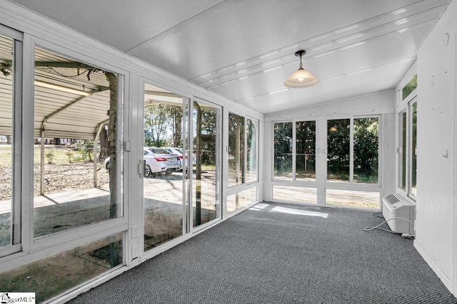 unfurnished sunroom featuring an AC wall unit and lofted ceiling