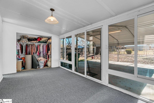 unfurnished sunroom featuring lofted ceiling with beams