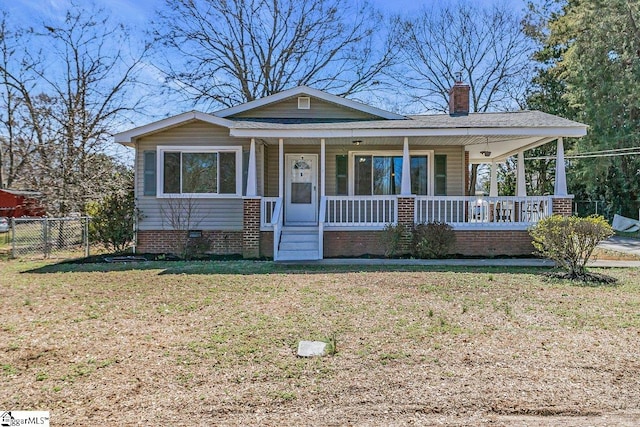 view of front of home featuring a front lawn, a porch, fence, crawl space, and a chimney