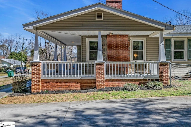 view of front of property with a porch and a chimney