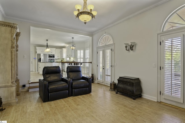 living room featuring baseboards, light wood-style floors, a chandelier, and crown molding