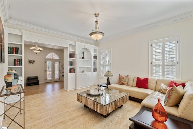 living room featuring a wealth of natural light, french doors, light wood-type flooring, and crown molding