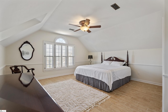 bedroom with visible vents, light wood-style flooring, baseboards, ceiling fan, and vaulted ceiling