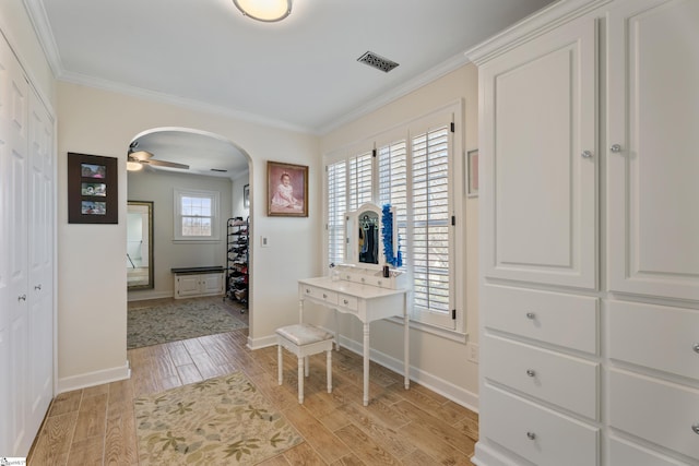 entrance foyer with baseboards, visible vents, arched walkways, crown molding, and light wood-type flooring