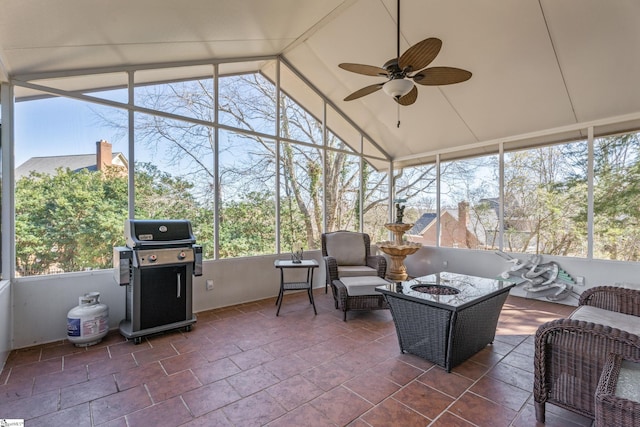 sunroom with ceiling fan and vaulted ceiling