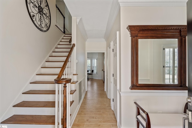 interior space featuring crown molding, stairway, a healthy amount of sunlight, and light wood finished floors