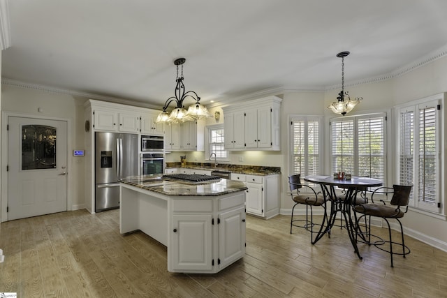 kitchen featuring plenty of natural light, appliances with stainless steel finishes, a center island, and light wood-style floors