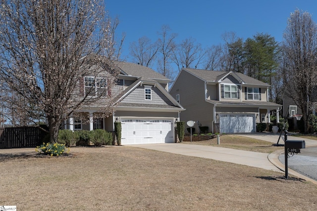 traditional home with concrete driveway, fence, and a garage