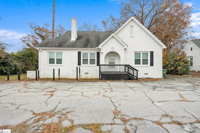 view of front of property with crawl space, brick siding, roof with shingles, and a chimney