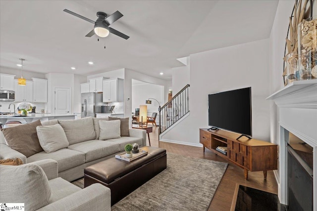 living room featuring recessed lighting, wood finished floors, stairs, and ceiling fan