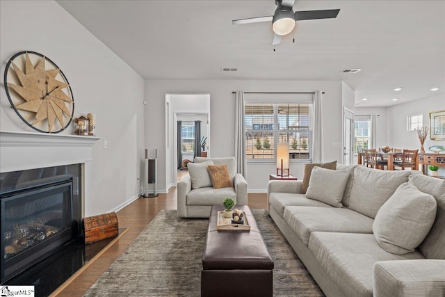 living area with baseboards, visible vents, a fireplace with flush hearth, recessed lighting, and dark wood-type flooring