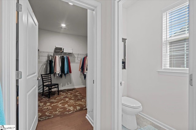 bathroom with visible vents, baseboards, toilet, and wood finished floors