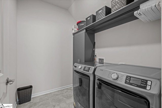 laundry room with laundry area, washing machine and dryer, and baseboards