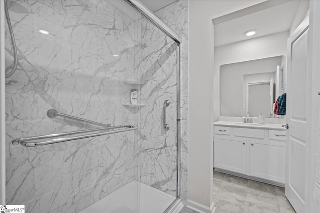 bathroom featuring a marble finish shower and vanity