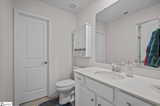 bathroom with vanity, toilet, and visible vents