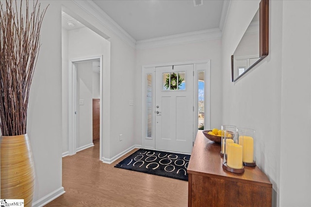 entrance foyer featuring baseboards, wood finished floors, and crown molding