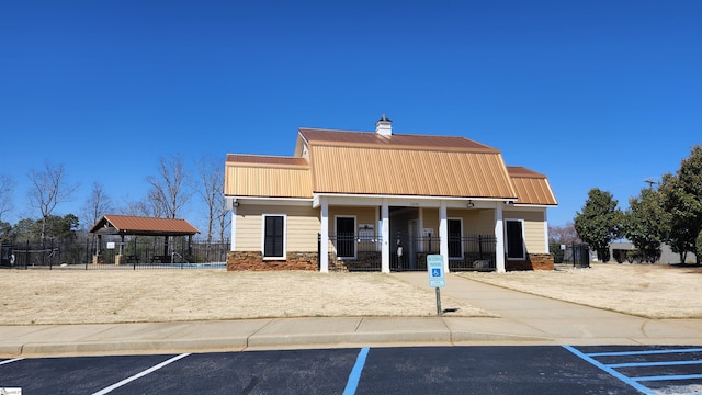 view of building exterior featuring uncovered parking and fence