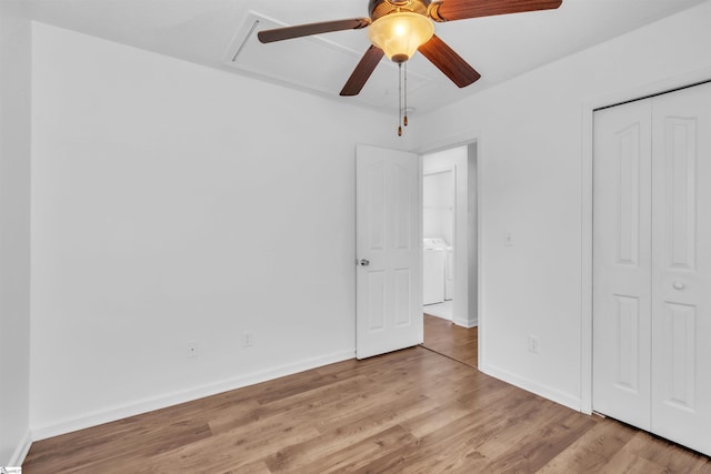 unfurnished bedroom with washer / clothes dryer, baseboards, a closet, and light wood finished floors