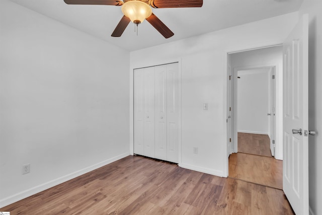 unfurnished bedroom featuring light wood-style floors, baseboards, a closet, and ceiling fan