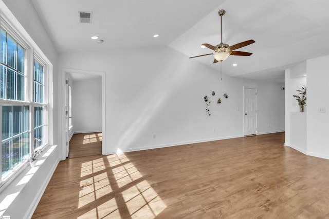 unfurnished living room featuring vaulted ceiling, plenty of natural light, and light wood-type flooring