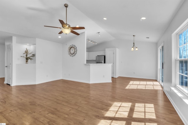 unfurnished living room with a ceiling fan, wood finished floors, baseboards, recessed lighting, and vaulted ceiling