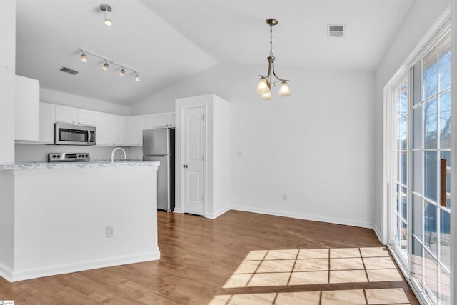 kitchen with light wood-type flooring, visible vents, white cabinetry, appliances with stainless steel finishes, and light stone countertops