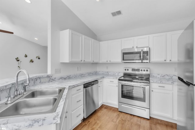 kitchen with visible vents, light wood-style flooring, a sink, stainless steel appliances, and white cabinetry