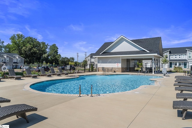 community pool with a patio and fence