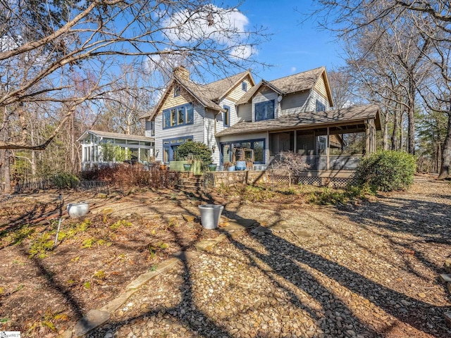 view of front of house featuring a chimney and a sunroom