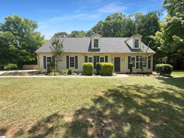 cape cod-style house with a front yard and roof with shingles