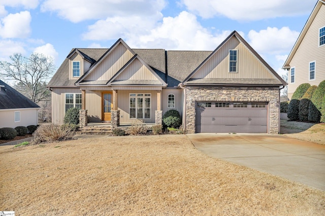 craftsman-style home featuring stone siding, driveway, and a shingled roof