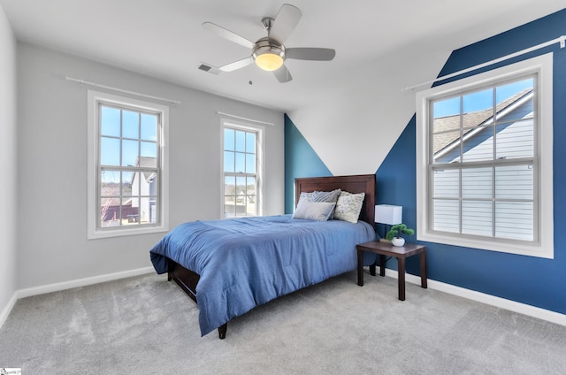 carpeted bedroom with visible vents, baseboards, lofted ceiling, and ceiling fan