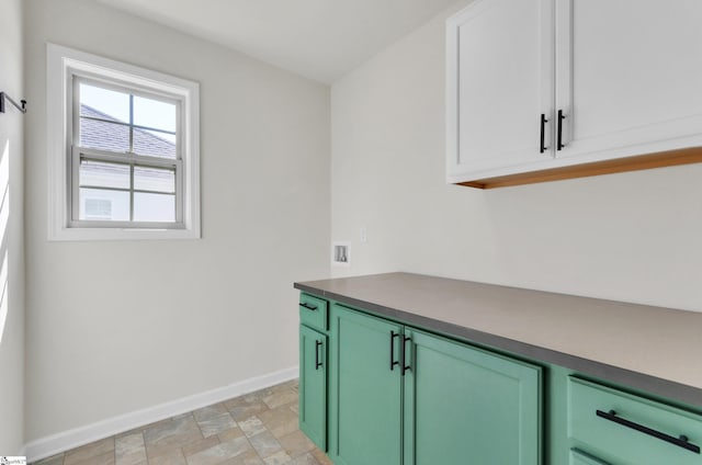 interior space featuring baseboards, cabinet space, and stone finish floor