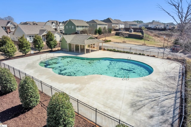 pool with a residential view, a patio, and fence