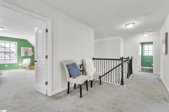 sitting room featuring an upstairs landing, visible vents, carpet flooring, and attic access