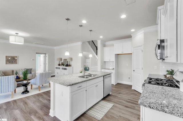 kitchen featuring a sink, stainless steel appliances, light wood-style floors, and crown molding