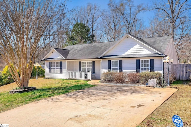 ranch-style home featuring covered porch, a front yard, and fence