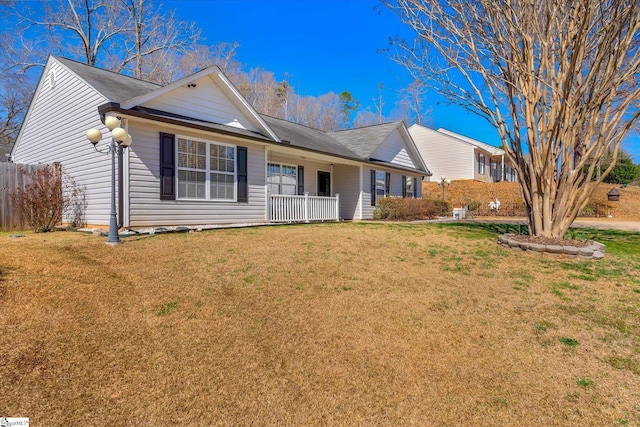 single story home with covered porch, a front lawn, and fence