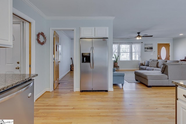 kitchen with white cabinets, light wood finished floors, appliances with stainless steel finishes, and ornamental molding