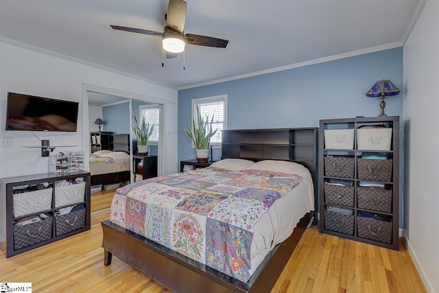 bedroom featuring ornamental molding, a ceiling fan, wood finished floors, a closet, and baseboards