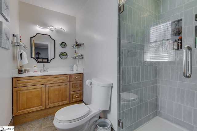 bathroom with vanity, a shower stall, and toilet