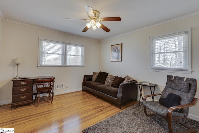 living area with visible vents, light wood-style floors, and crown molding