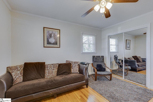 living room featuring a ceiling fan, wood finished floors, and crown molding