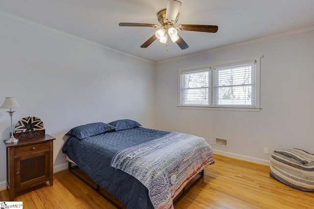 bedroom with visible vents, light wood-style flooring, crown molding, and baseboards