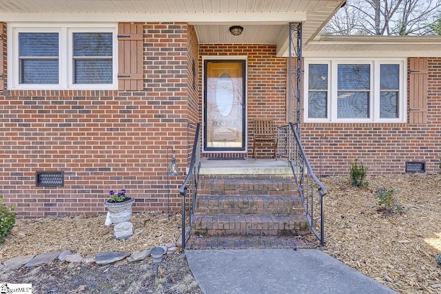 doorway to property with crawl space and brick siding